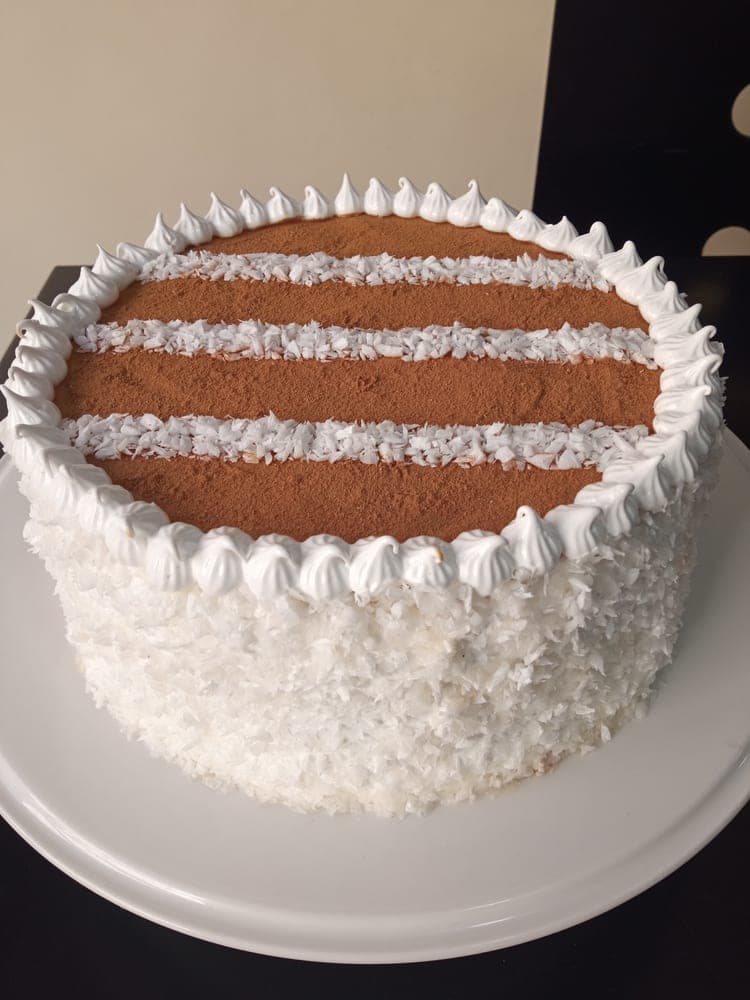 Torta de bienmesabe cubierta de coco rallado y franjas de canela