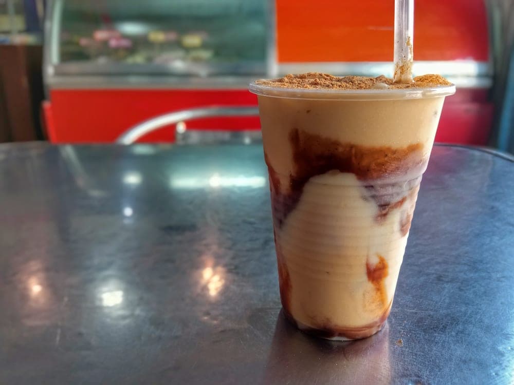 Chicha venezolana de arroz servida en vaso, con canela por encima
