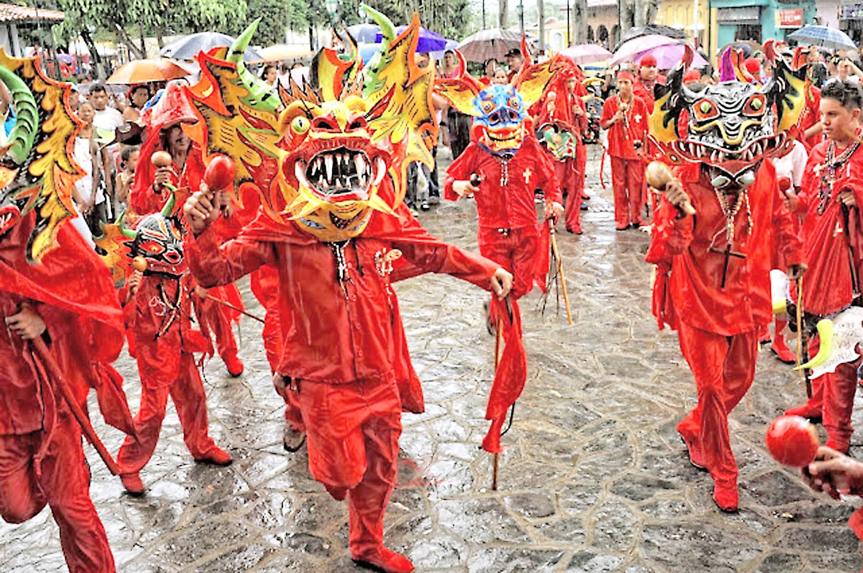 Diablos Danzantes de Yare con máscaras puestas y trajes rojos de cuerpo entero