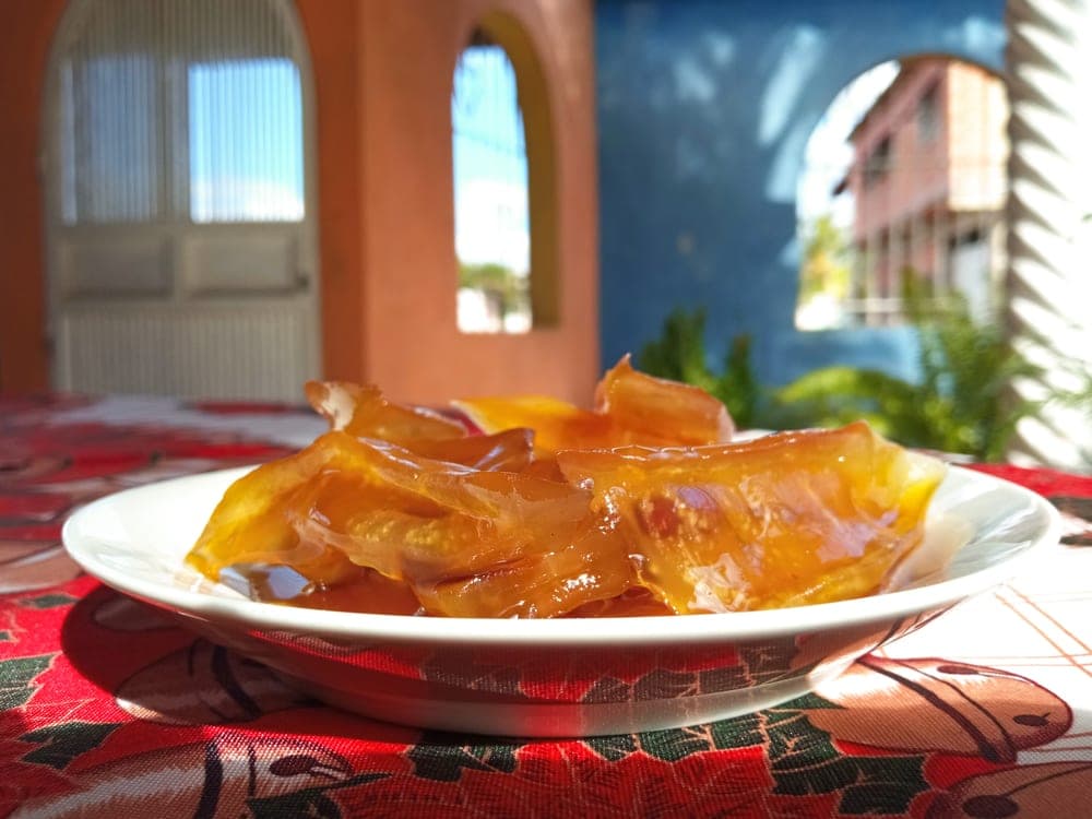 Dulce de lechosa en almíbar dorado, servido en un plato