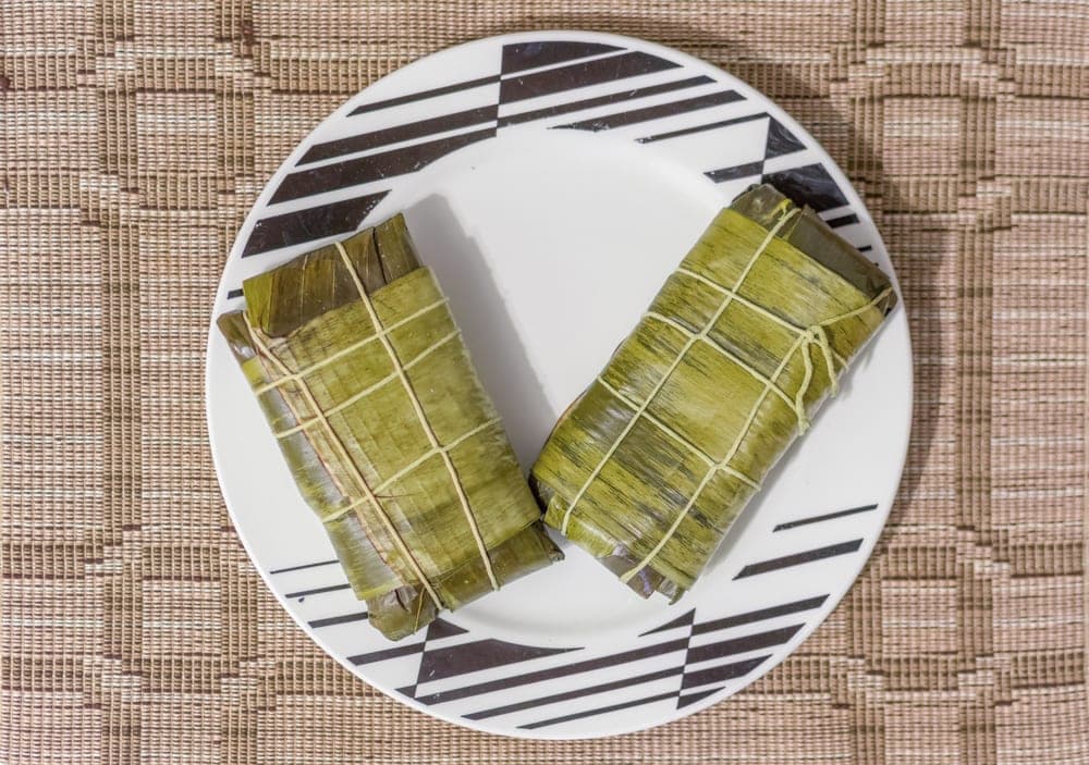 Dos hallacas amarradas en hoja de plátano