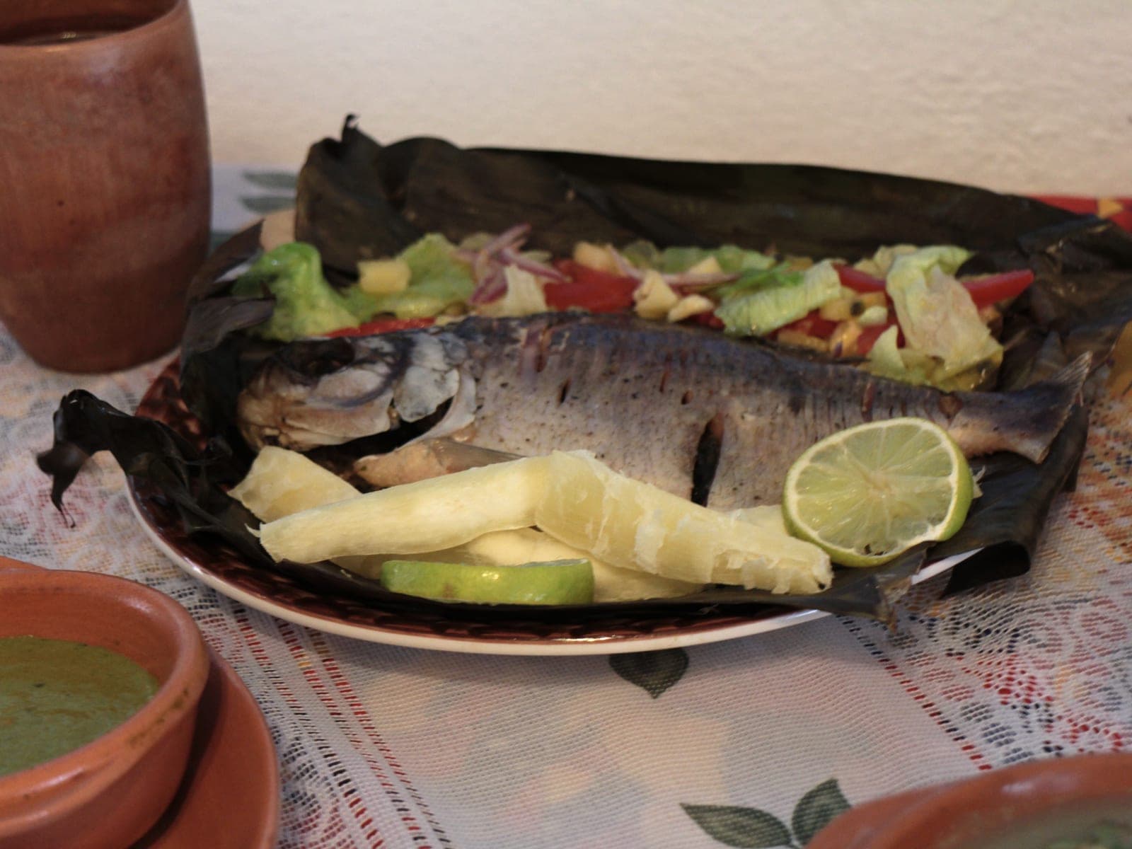 Pescado de río sobre hoja de plátano, con yuca y ensalada, en Amazonas