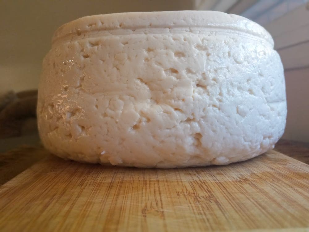 Rueda de queso llanero sobre una tabla de madera