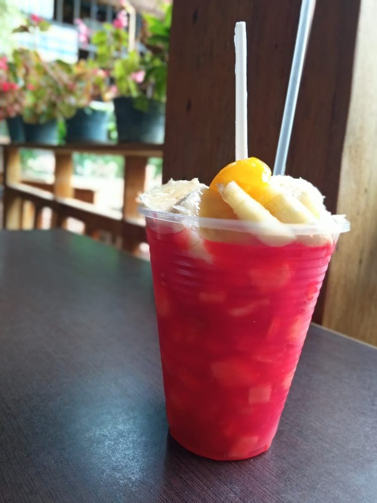 Vaso de tizana roja con trozos de fruta